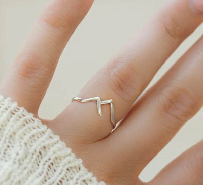 Mountain-shaped copper ladies ring worn on finger with minimalist design and textured metal finish